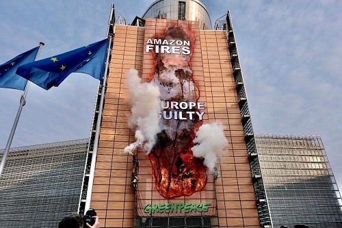 Greenpeace 'hackea' la sede de la Comisión Europea con una imagen gigante de los incendios de la Amazonía