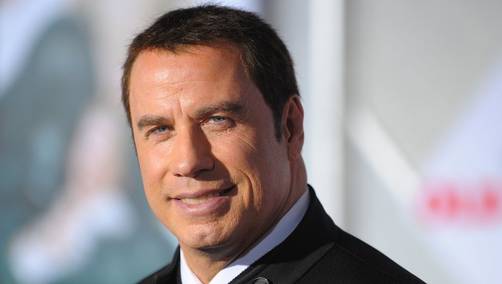 John Travolta coquetea con camarero frente a su esposa