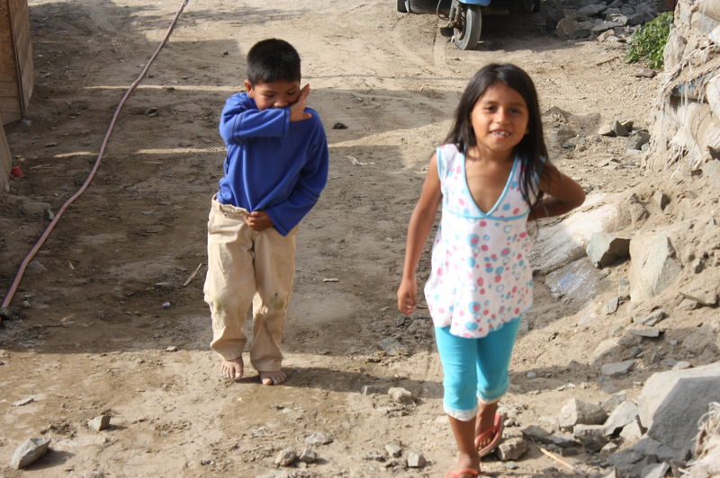 Niños caminan descalzos por las arenosas calles del Asentamiento Humano Los Jardines en Mi Perú - Ventanilla