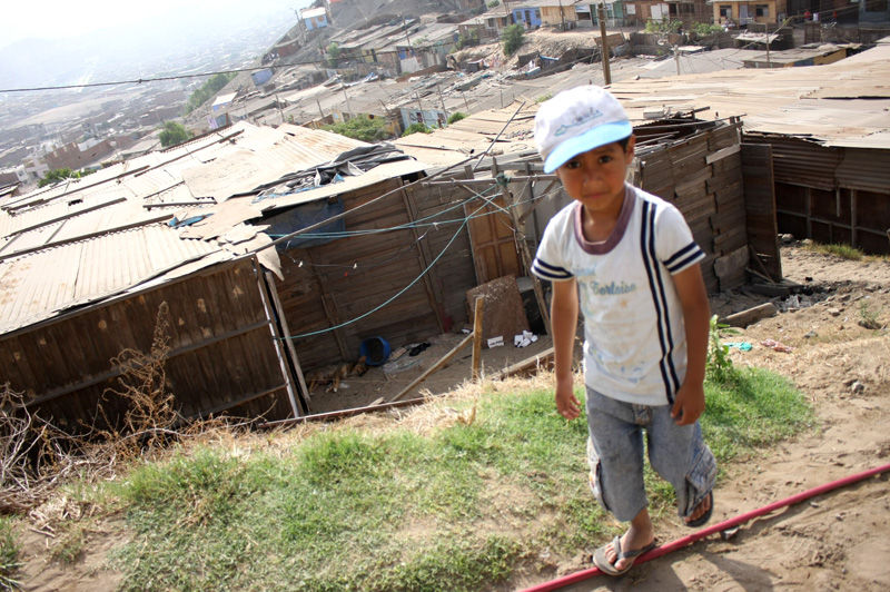 Niños caminan descalzos por las arenosas calles del Asentamiento Humano Los Jardines en Mi Perú - Ventanilla