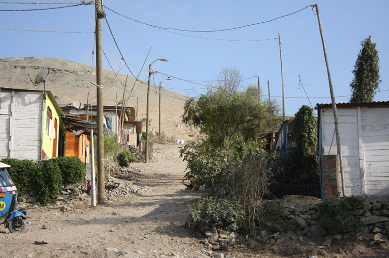 Niños caminan descalzos por las arenosas calles del Asentamiento Humano Los Jardines en Mi Perú - Ventanilla