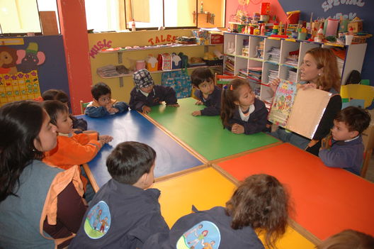Niños residentes en el distrito de Los Olkivos leyendo unos cuentos