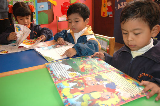 Niños residentes en el distrito de Los Olkivos leyendo unos cuentos