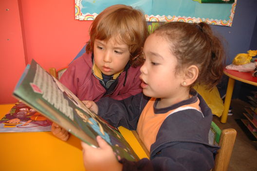 Niños residentes en el distrito de Los Olkivos leyendo unos cuentos