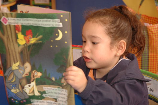 Niños residentes en el distrito de Los Olkivos leyendo unos cuentos