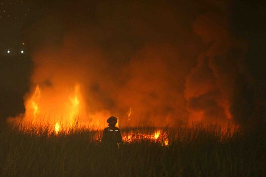 Miembros del cuerpo de bomberos sofocan las llamas de un incendio