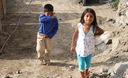 Niños caminan descalzos por las arenosas calles del Asentamiento Humano Los Jardines en Mi Perú - Ventanilla