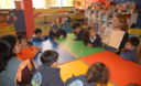 Niños residentes en el distrito de Los Olkivos leyendo unos cuentos
